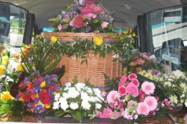 Wicker coffin covered in flowers
